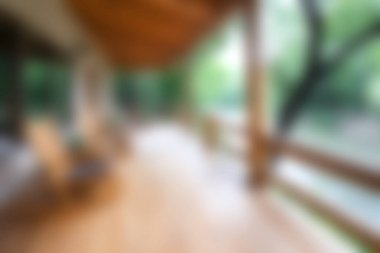 Bu bulanık görüntü huzurlu bir veranda görüntüsü yakalıyor. Yeşilliklerle çevrili doğal bir ortamda rahatlama ve sükunet hissi uyandırıyor..