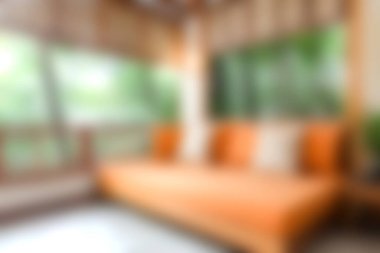 Parlak turuncu bir kanepe, bol doğal ışık ve çevreleyen yeşillik, sakin bir atmosferde rahatlamak ve rahatlamak için mükemmel..