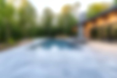 Serin bir arka bahçe havuzu manzarası. Etrafı yeşilliklerle çevrili temiz su sergileniyor. Rahatlamak ve yaz tatili için mükemmel. Boş zaman ve açık havada yaşamak için ideal bir estetik..