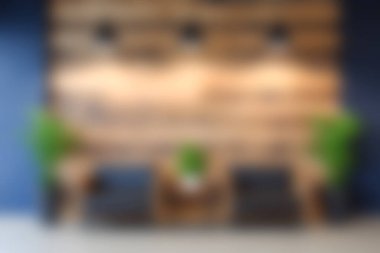 Bu resim, ahşap bir duvar ve yeşil bitkilerin bulunduğu rahat bir dinlenme alanı sergiliyor, rahat ve konforlu bir ortam yaratıyor..