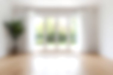 Bu resim, doğal ışığı davet eden geniş pencereli parlak ve ferah bir odayı tasvir ediyor. Minimalist tasarım konfor ve sükunet atmosferini arttırır..