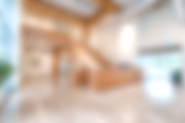 Bu resim, ziyaretçiler ve misafirler için misafirperver bir ortam yaratan bol doğal ışık ve ahşap özelliklere sahip modern ve zarif bir lobiyi gösteriyor..