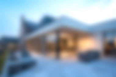 Bu modern evde günbatımında çağdaş mimari tasarımı olan şık bir açık hava yaşam alanı sergileniyor. Bulanık arka plan huzurlu bir ortam yaratır..