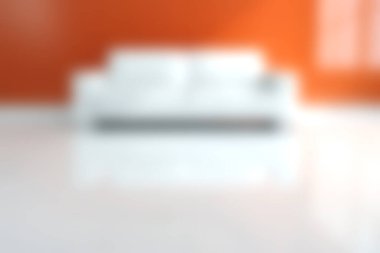 Şık bir oturma odasında canlı turuncu bir duvara karşı beyaz bir kanepe sergilenir. Bu modern iç tasarım rahat ve davetkar bir atmosfer sunuyor, rahatlamak için mükemmel..