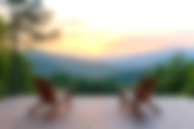 Gün batımında çarpıcı bir dağ manzarasına bakan tahta sandalyelerle huzurlu bir anın tadını çıkarın. Bu sakin dış mekan rahatlama ve sükuneti davet ediyor..