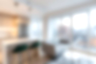 Bu resim doğal ışıkla dolu modern bir yaşam alanını gösteriyor. Konforlu mobilyalar, geniş pencereler ve rahatlamak için mükemmel bir hoş geldin atmosferi var..