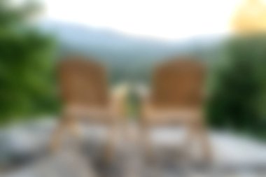 İki rahat ahşap sandalye izleyicileri dinlenmeye ve gün doğumunda nefes kesici bir dağ manzarasının tadını çıkarmaya davet ediyor. Huzuru ve doğal güzelliği, sakin bir doğa ortamında yakalıyor..