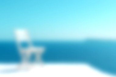 Sakin mavi okyanus tarafından yerleştirilmiş yalnız bir sandalyenin yer aldığı sakin bir sahne rahatlama ve sükunet için mükemmel bir atmosfer yaratıyor. Tatil temaları için mükemmel.