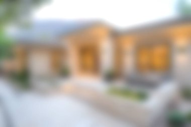 Konforlu, modern bir evin dış görünüşü alacakaranlıkta sıcak ışıklar sergiliyor, sakin bir mahallede geçiyor, davetkar ve barışçıl bir atmosfer yaratıyor..