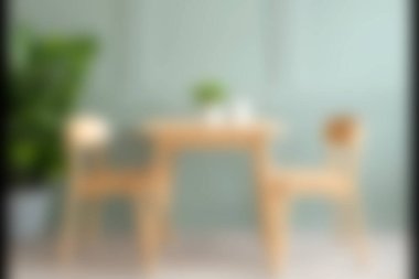 Yumuşak yeşil duvarlı, ahşap masa ve sandalyelerin bulunduğu rahat ve modern bir yemek alanı keşfedin. Ev ya da yaşam tarzı temaları için mükemmel.