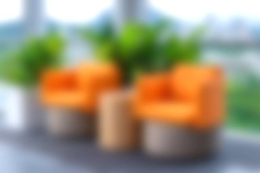 Beraberinde iki şık turuncu sandalye ve yemyeşil bitkiler modern bir iç mekan ortamında davetkar bir atmosfer yaratıyor, rahatlama ve estetik cazibe için mükemmel..