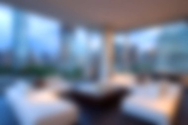 Bu resim konfor için tasarlanmış modern bir yaşam alanını gözler önüne seriyor, alacakaranlıkta şehrin ufuk çizgisini güzelce çerçeveleyen büyük pencereler var..