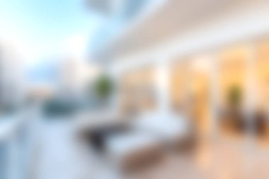 Açık hava balkonunda modern koltuklar ve arka planda şık bir şehir silueti var. Rahatlamak için rahat ve davetkar bir atmosfer yaratıyor..