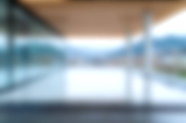 Bolca doğal ışığın ve huzurlu manzaranın bulanık görüntüsünün yer aldığı modern mimari iç mekan. Tasarım sükuneti ve zarafeti vurguluyor..