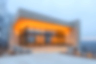 Alacakaranlıkta aydınlanan, dingin doğayla çevrili büyüleyici bir modern ev. Bu resim, çağdaş mimarinin tasarımı ve güzelliğini huzurlu bir ortamda yakalar..