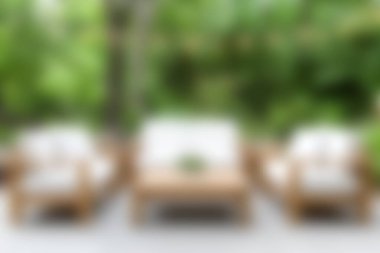 Zarif ahşap mobilyaların, rahat yastıkların ve yemyeşil çimlerin bulunduğu sakin bir açık hava salonu rahatlama ve rahatlama için mükemmel bir kaçış sağlar..