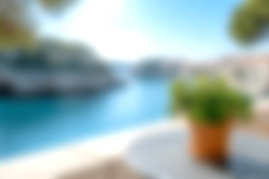 Huzurlu bir kıyı manzarası bulanık bir ön planda sakin mavi bir su zeminine karşı saksı bitkisi sergiliyor. Seyahat ve rahatlama temaları için mükemmel.