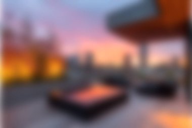 Bu görüntü modern mobilyaların bulunduğu şık bir çatı salonu yakalıyor, canlı bir şehirde nefes kesen bir günbatımına karşı..