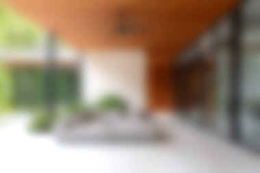 Bu görüntü, yumuşak bir doğal ışık ortamında canlı yeşilliklerle çevrili parlak mobilyalarla dolu, sakin ve davetkar bir atmosfer sunan modern bir açık hava alanı yakalıyor..