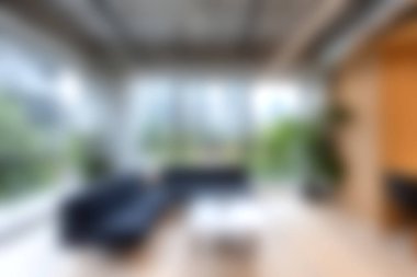 Parlak ve ferah oturma odasında doğal ışık getiren büyük pencereler, rahat mobilyalar ve bereketli bitkiler, huzurlu bir atmosfer yaratıyor..