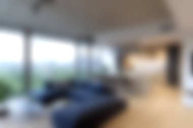 Bu resim modern bir oturma odasını, şık mobilyaları ve geniş pencereleri olan, doğal ışığı mekana davet eden bir odayı gösteriyor. Tasarım rahatlığı ve zarafeti vurguluyor..