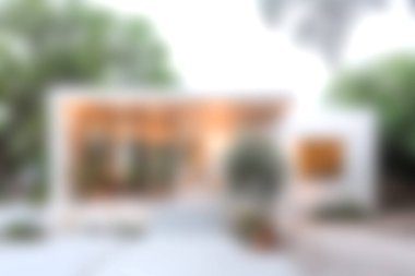 Çağdaş mimari zarafet ve sükuneti gösteren, yemyeşil ve ağaçlarla çevrili, modern bir cepheye sahip, güzel tasarlanmış minimalist bir ev..