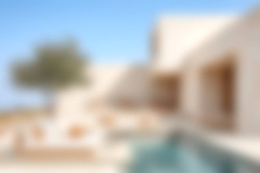 Çağdaş bir minimalist villanın sakin manzarası, açık mavi gökyüzü altında rahatlamak için mükemmel bir havuz alanı sunuyor. Lüks seyahat temaları için ideal.