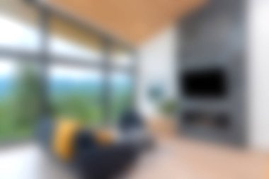 Doğal ışığı davet eden, manzaralı bir manzara sunan geniş pencereli modern bir oturma odası. Mobilyalar rahat bir atmosfer yaratıyor..