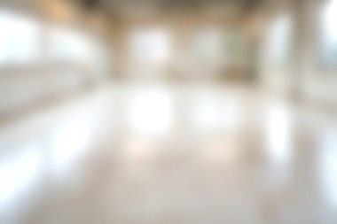 Bu görüntü, modern bir iç mekanın bulanık bir görüntüsünü yakalıyor. Parlatılmış zemin ve bol doğal ışık ile dolu geniş bir oda, dingin bir ortam yaratıyor..