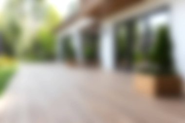 Güzel tasarlanmış, ahşap bir güverte, yemyeşil bitkiler ve bol doğal ışık içeren, rahatlamak ve eğlenmek için ideal bir açık hava alanı..