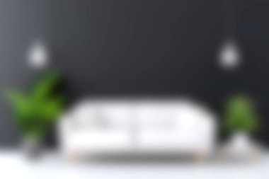 Bu resim, yemyeşil bitkilerle süslenmiş beyaz bir kanepeyi ve koyu renkli bir duvara dayanan parlak kolye ışıklarıyla modern ve davetkar bir atmosfer yaratan şık bir oturma odasını gösteriyor..