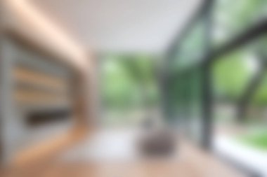 Bu görüntü, minimalist tasarım ve doğal ışığı vurgulayarak yemyeşil alana açılan geniş cam pencereli modern bir iç mekan yakalar..