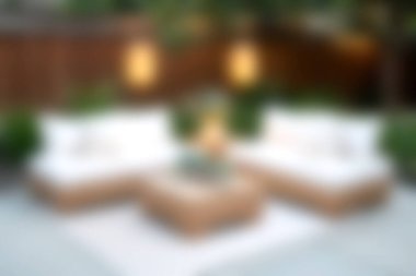 Modern bir açık hava yaşam alanı tasviri, rahat koltuklar, hafif ışıklandırma ve sakin bir bahçe atmosferi, rahatlama ve rahatlama için mükemmel..