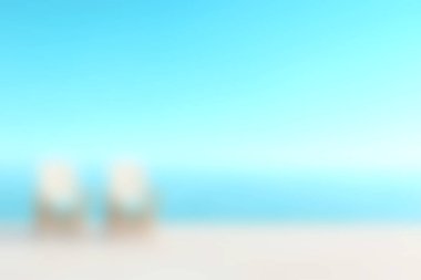 Bu sakin plaj sahnesinde iki boş şezlong, açık mavi gökyüzü ve okyanusun arka planına karşı. Rahatlama ve tatil titreşimleri için mükemmel..