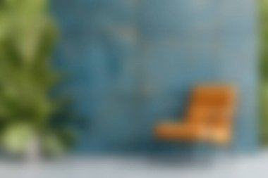 Berrak yeşil bitkilerle çevrili, şık ahşap bir sandalyenin olduğu sakin bir salon sahnesi, rahatlama ve ilham için mükemmel..