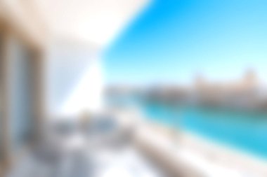 Parlak bir balkon, berrak mavi gökyüzünün altında nefes kesici bir okyanus manzarası sunuyor, modern bir ortamda rahatlama ve rahatlama için mükemmel, tatil için ideal..