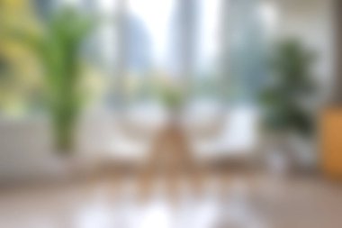 Modern mobilyaların ve yemyeşil bitkilerin yer aldığı sakin bir iç mekan. Yumuşak doğal ışık, rahatlamak için ideal, sakin bir atmosfer yaratır..