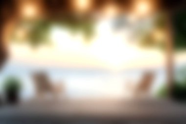 Sakin su, rahat sandalyeler ve sıcak ortam aydınlatmasının yer aldığı sakin bir günbatımı sahnesi, rahatlama ve keyif için huzurlu bir atmosfer yaratıyor..