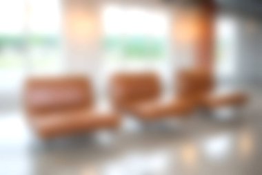 Bu görüntü, parlak doğal ışıkla yıkanmış yumuşak kahverengi deri koltukların bulunduğu modern bir bekleme alanı yakalıyor, rahat ve davetkar bir yer yaratıyor..