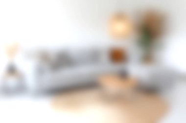 Modern beyaz bir kanepe, ahşap bir sehpa, şık bir lamba ve yeşil bir bitki içeren rahat bir oturma odası davetkar ve rahatlatıcı bir atmosfer yaratıyor..