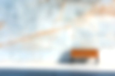 Eski model bir araba, görkemli dağlar ve açık mavi gökyüzü ile çevrili karla kaplı bir arazide huzur içinde yatıyor. Seyahat temaları için mükemmel.