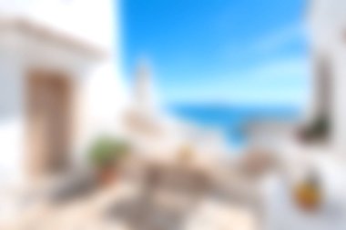 Okyanusa bakan, güneş ışığıyla yıkanmış, bembeyaz bir terasın yer aldığı sakin bir sahil manzarası. Tatil ve rahatlama temaları için ideal.