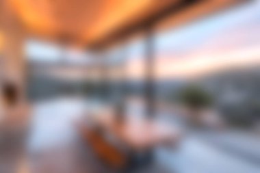 Bu modern oturma odasında nefes kesen bir manzara üzerinde çarpıcı bir günbatımı gösteren geniş pencereler var. Huzur ve sıcaklık atmosferi yaratıyor..