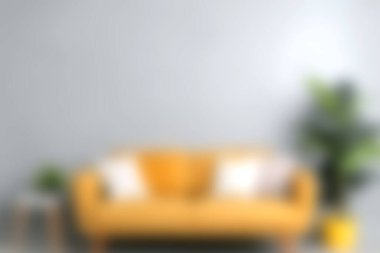 Parlak ve cezbedici modern oturma odası dekoratif yastıklı sarı bir kanepe, canlı bir saksı bitkisiyle tamamlanmış, ev dekorasyonu için ideal..