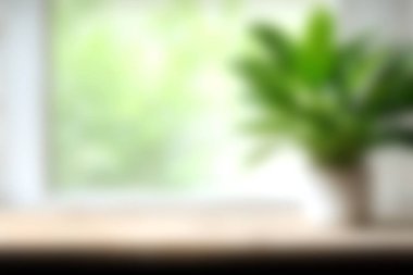 Parlak bir pencerenin yanında yeşil bir bitkinin yer aldığı sakin bir iç görüntü. Yumuşak odak, ev dekorasyonu ya da yaşam tarzı temaları için mükemmel bir sakinleştirici atmosfer yaratır..