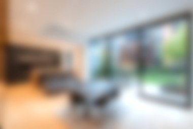 Doğal ışık ve bereketli yeşilliği davet eden geniş pencereli modern bir minimalist oturma odası. Gösterişli tasarım rahatlatıcı bir atmosfer yaratıyor..