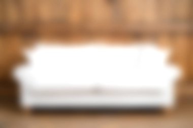 Bu resim, sade ahşap bir duvara dayalı zarif beyaz bir kanepe içeriyor. Sıcak ve davetkar bir atmosfer yaratıyor. İç tasarım kavramları için ideal..