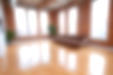 Bu resim, geniş pencereli, ahşap döşemeli ve minimalist dekorlu, parlak ve davetkar bir atmosfer yaratan modern bir daireye sahiptir..