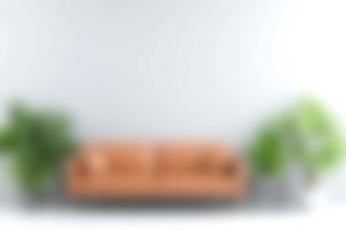 Parlak ve davetkar bir oturma odası. Etrafı yemyeşil bitkilerle çevrili şık bir kanepe. Huzurlu ve modern bir iç mekan yaratıyor..