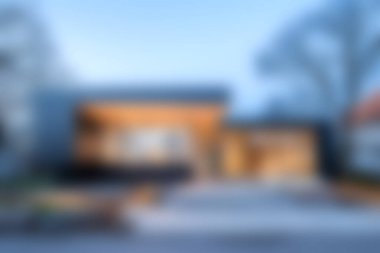 Göz kamaştırıcı modern bir ev, geniş pencereleri ve minimalist ahşap cepheli, sakin doğayla çevrili, çağdaş yaşam için mükemmel mimarisini sergiliyor..